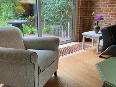 a living room with a couch and a table and a window at Villa bij bos en centrum in Bergen