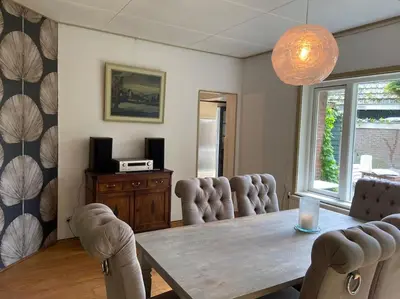 a dining room with a wooden table and chairs at Villa bij bos en centrum in Bergen
