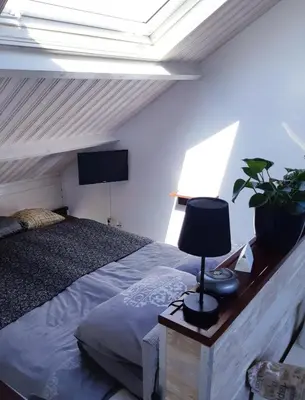 a bedroom with a bed with a lamp and a tv at Studio Vúr de Diek in Spakenburg