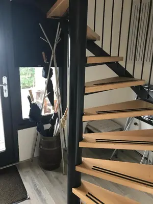 a set of wooden stairs in a room with a plant at Studio Vúr de Diek in Spakenburg