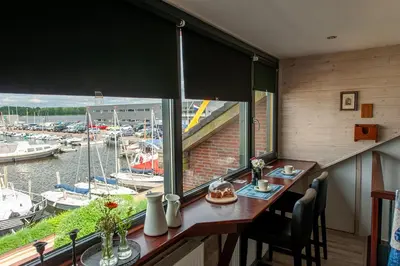 a dining room with a view of a marina at Studio Vúr de Diek in Spakenburg