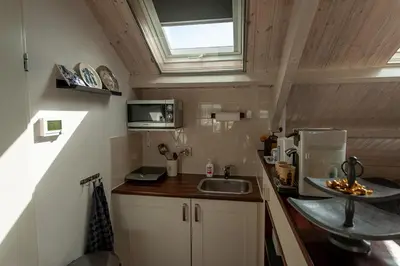 a small kitchen with a sink and a microwave at Studio Vúr de Diek in Spakenburg