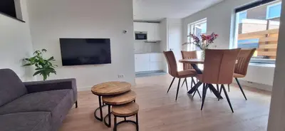 a living room with a couch and a table and chairs at Miles in Egmond aan Zee