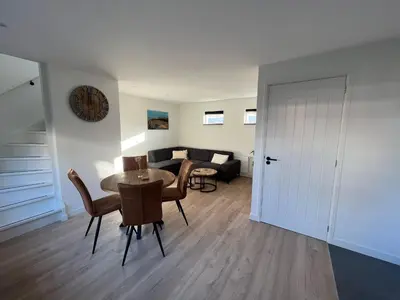 a living room with a table and chairs and a couch at Miles in Egmond aan Zee