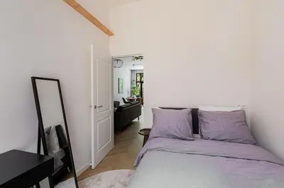 a bedroom with a bed with purple sheets and a mirror at Stylish apartment next to the Amstel river- Unit D in Amsterdam