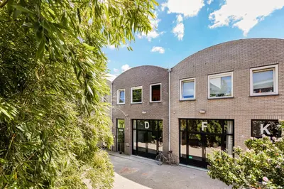 a brick building with glass doors and a bike parked outside at Stylish apartment next to the Amstel river- Unit D in Amsterdam