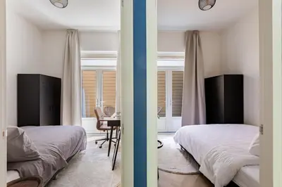 a bedroom with two beds and a desk in it at Stylish apartment next to the Amstel river- Unit D in Amsterdam
