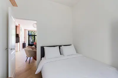 a bedroom with a white bed with white pillows at Stylish apartment next to the Amstel river- Unit F in Amsterdam