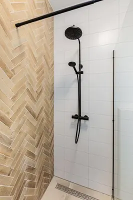 a shower in a bathroom with white tiles at Stylish apartment next to the Amstel river- Unit F in Amsterdam