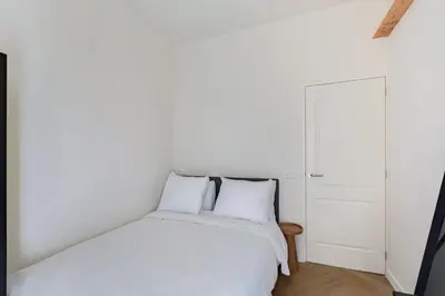 a bedroom with a white bed with two pillows at Stylish apartment next to the Amstel river- Unit F in Amsterdam