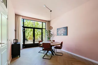 a dining room with a table and a large window at Stylish apartment next to the Amstel river- Unit F in Amsterdam