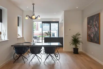 a dining room and living room with a dining table at Villa Harry with private parking in Zandvoort