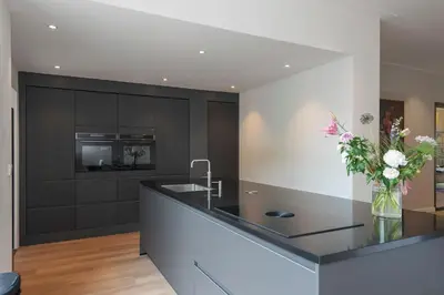 a kitchen with a counter with a vase of flowers at Villa Harry with private parking in Zandvoort