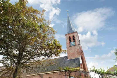 a church with a tower with a clock on it at Villa Harry with private parking in Zandvoort
