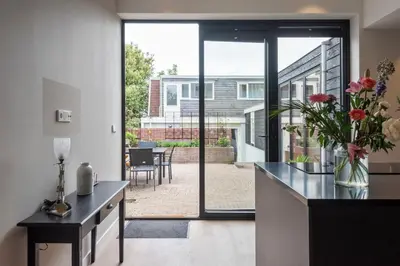 a kitchen with a large sliding glass door with a patio at Villa Harry with private parking in Zandvoort
