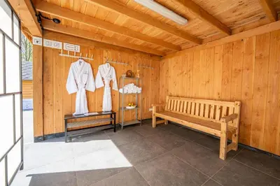 a room with a wooden wall with a bench at Blue Tiny House with HotTub in Zeewolde