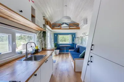 a kitchen and living room of a tiny house at Blue Tiny House with HotTub in Zeewolde