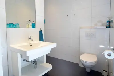 a white bathroom with a sink and a toilet at Bed & Breakfast Hotel Malts in Haarlem