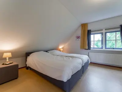 a bedroom with a bed and a window at Schoorlse Duinvoet in Schoorl