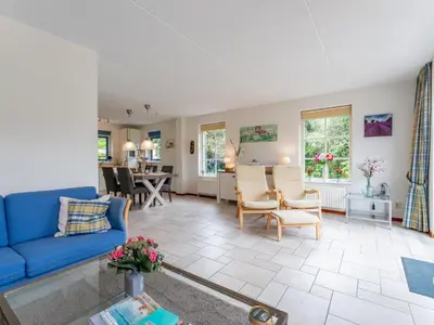 a living room with a blue couch and chairs at Schoorlse Duinvoet in Schoorl