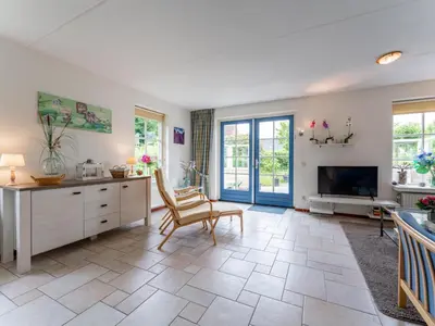 a large living room with a tv and a chair at Schoorlse Duinvoet in Schoorl