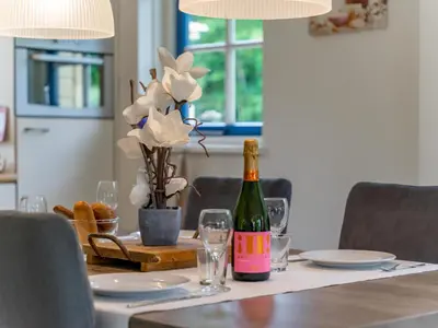 a bottle of wine sitting on a table with glasses at Schoorlse Duinvoet in Schoorl