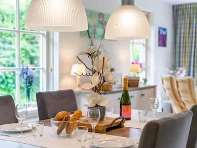 a dining room table with two lamps and a bottle of wine at Schoorlse Duinvoet in Schoorl
