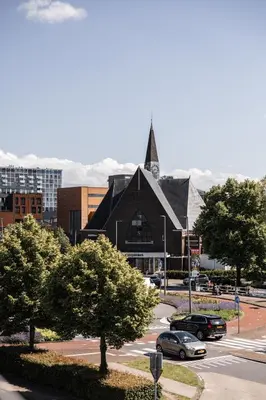 a large black church with a steeple in a city at Hotel Twenty-Three Amsterdam Airport in Hoofddorp