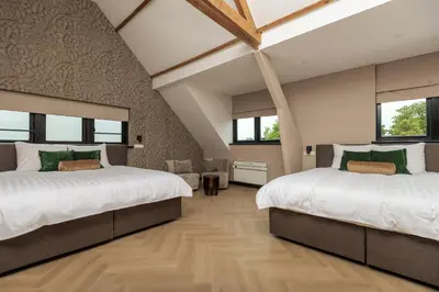two beds in a room with two windows at Hotel Twenty-Three Amsterdam Airport in Hoofddorp