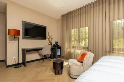 a bedroom with a bed and a flat screen tv at Hotel Twenty-Three Amsterdam Airport in Hoofddorp