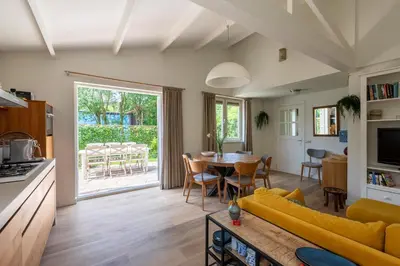 a living room with a yellow couch and a table at Beautifully located dune villa near Noordwijk beach in Noordwijk