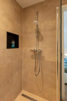 a shower with a shower head in a bathroom at Beautifully located dune villa near Noordwijk beach in Noordwijk