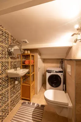 a bathroom with a toilet sink and a washing machine at Beautifully located dune villa near Noordwijk beach in Noordwijk