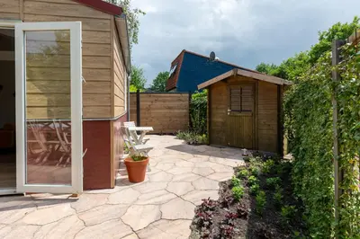 a garden with a shed and a patio at Beautifully located dune villa near Noordwijk beach in Noordwijk