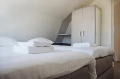 a bedroom with two beds with white towels on them at Zonnestralen in Egmond aan den Hoef