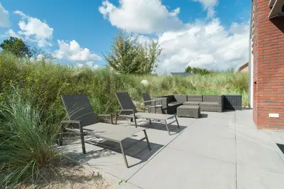 a group of chairs and tables on a patio at Zonnestralen in Egmond aan den Hoef