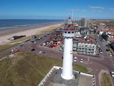 an aerial view of a lighthouse next to a beach at Zonnestralen in Egmond aan den Hoef
