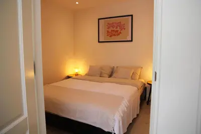 a bedroom with a white bed with a picture on the wall at Casa Fiore in Bergen