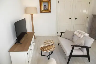 a living room with a couch and a flat screen tv at Casa Fiore in Bergen
