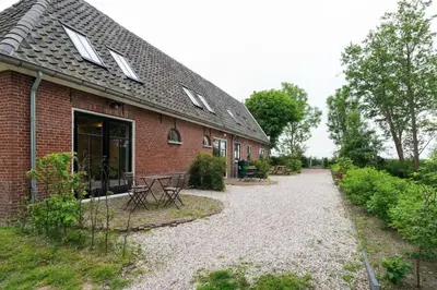 a brick building with a patio and a table at Beautiful House in The Middle of Nature in Abcoude
