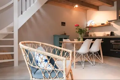 a kitchen with a table and some white chairs at Beautiful House in The Middle of Nature in Abcoude