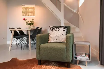 a living room with a chair and a table at Beautiful House in The Middle of Nature in Abcoude