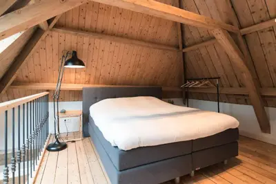 a bedroom with a large bed in a attic at Beautiful House in The Middle of Nature in Abcoude