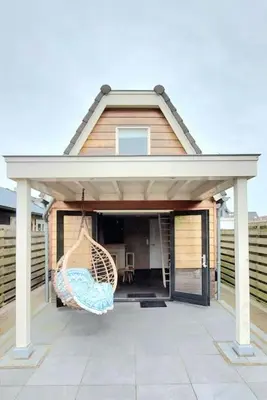 a house with a porch with a hammock on a patio at Have a nice stay! - Trendy Vakantiehuis Carpe Diem met eigen tuin in Noordwijk