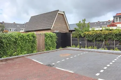 a brick parking lot in front of a house at Have a nice stay! - Trendy Vakantiehuis Carpe Diem met eigen tuin in Noordwijk