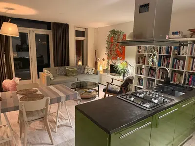 a kitchen and a living room with a stove top oven at Perfectly located charming apartment MAGDALENA HOUSE for true connoisseurs in Haarlem