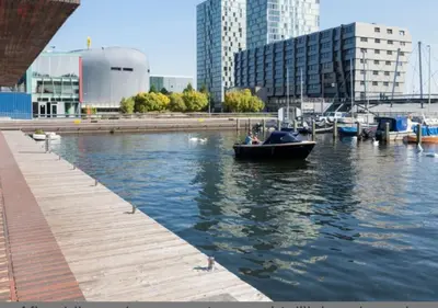 a small boat in the water next to a dock at In Almere, Close to Amsterdam in Almere