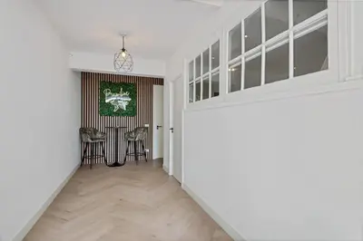 a hallway with white walls and a hallway with chairs at Bamboe Suite Bentveld met ligbad en gratis parkeren in Bentveld