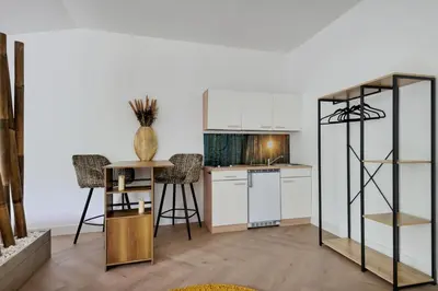 a kitchen with a counter and a table with chairs at Bamboe Suite Bentveld met ligbad en gratis parkeren in Bentveld