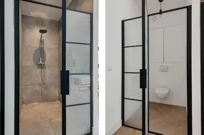 a glass shower door in a bathroom with a toilet at Bamboe Suite Bentveld met ligbad en gratis parkeren in Bentveld